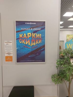Реклама в фитнес-клубах Омска: плакат в рамке на стене у гардероба