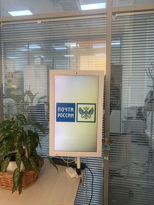 Реклама в отделениях Почты России в Омске: вертикальный экран на настольной стойке с заставкой почты